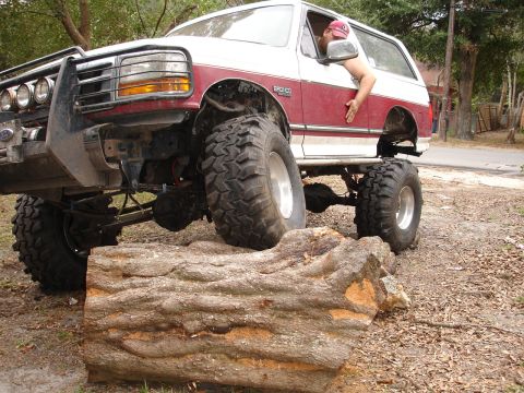 1989 Ford Bronco - A modified Ford Bronco navigates an obstacle course with a driver's arm out the window.