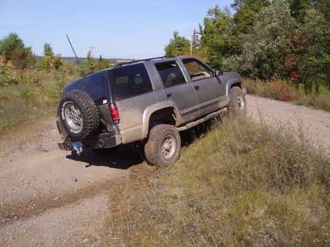2000 Chevrolet Tahoe - This SUV appears to be from the mid-1990s, not a 2000 model, as it navigates a rough, unpaved path.