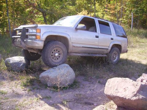 2000 Chevrolet Tahoe - This SUV is navigating a rocky obstacle course in a wooded area.