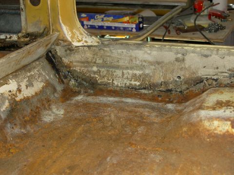 1967 Ford Ranchero - Close-up view of a heavily rusted vehicle interior floor pan and structural components.
