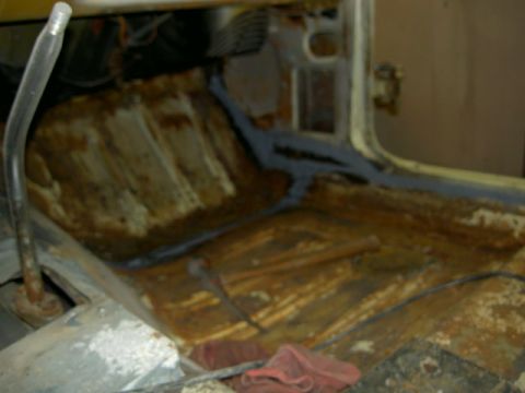 1967 Ford Ranchero - Vehicle interior with significant rust damage on the floor and seat supports.