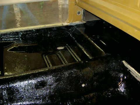 1967 Ford Ranchero - Undercarriage of a vehicle with black protective coating applied to the floor pan.