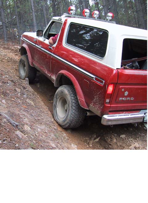1995 Ford Bronco - Ford Bronco navigates a steep, muddy off-road trail.
