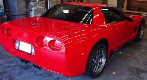 2002 Ford F-150 - This red sports car has a distinctive rear design with quad exhaust pipes and aftermarket wheels.