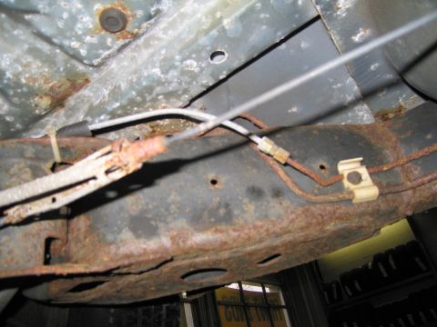 1991 Ford LTD Crown Victoria - Close-up view of a heavily rusted vehicle frame with brake lines and clips.