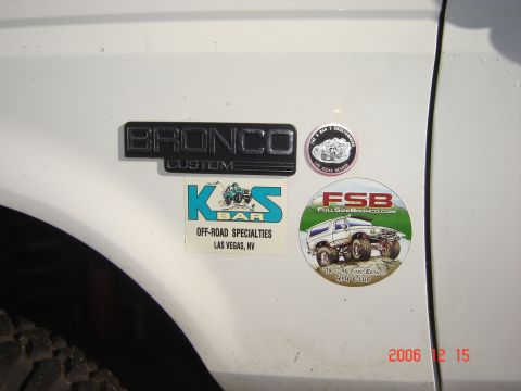 1993 Ford Bronco - Bronco Custom emblem and off-road stickers are visible on the fender of a white vehicle.