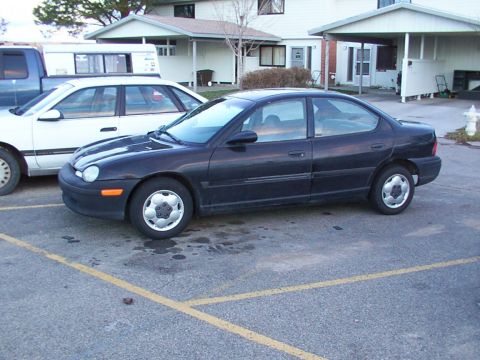 2003 Ford Ranger - A dark sedan is parked in a lot next to other vehicles.