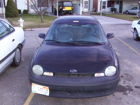 2003 Ford Ranger - A dark sedan is parked in a lot, showing its front end and license plate.
