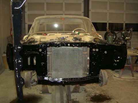 1967 Ford Ranchero - The front clip of a vehicle is disassembled and undergoing work in a garage setting.