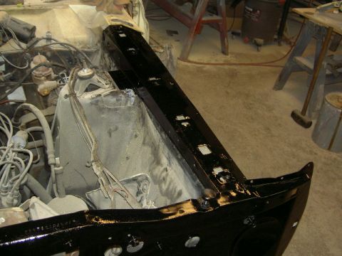 1967 Ford Ranchero - Engine bay of a 1967 Ford Ranchero undergoing restoration, showing a freshly painted black frame rail.