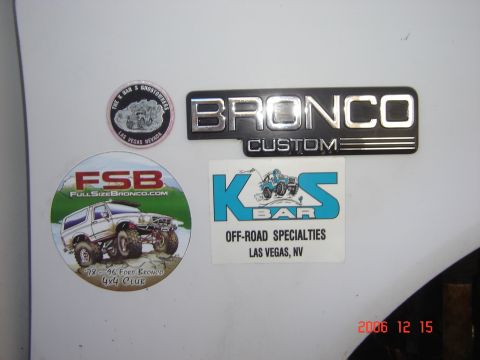 1993 Ford Bronco - A Bronco Custom emblem is affixed next to stickers related to Ford Bronco enthusiasts.