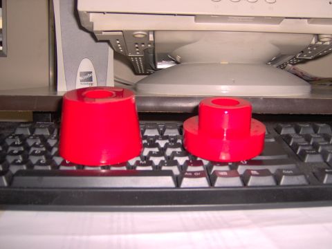 1992 Ford Bronco - Two red polyurethane bushings are placed on a black keyboard in front of a computer monitor.