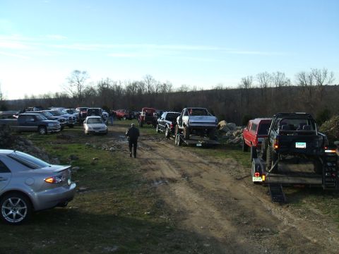1995 Ford Bronco - A collection of vehicles, including trucks and cars, are gathered in an outdoor lot.