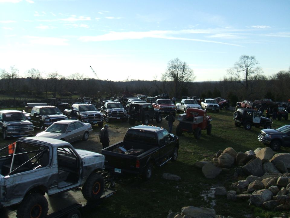 Silver 1995 Ford Bronco with roll cage and large tires, parked outdoors with other vehicles