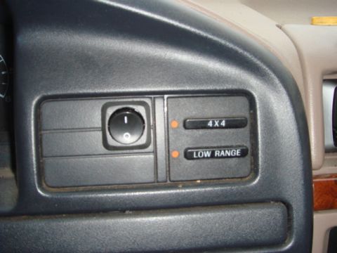 1996 Ford Bronco - Close-up of the dash switch panel left of the steering column showing a round rotary knob and the electronic-shift four-wheel-drive indicat…