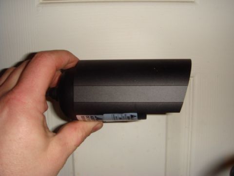 1996 Ford Bronco - Black electronic device with a label is held in a hand against a white background.