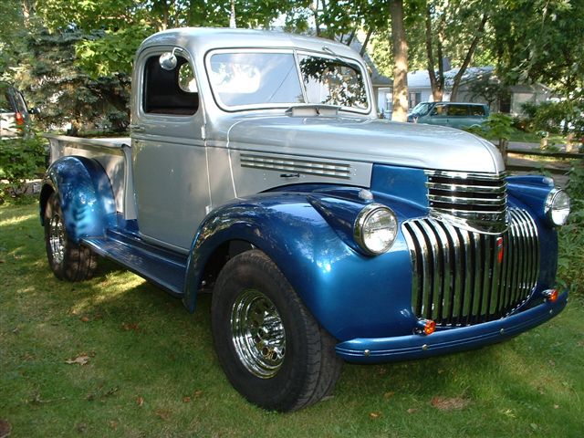 Two-tone silver and blue 1941 Chevrolet pickup truck parked on grass