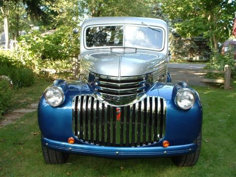 1946 Chevrolet C/K Pickup - This vintage pickup truck features a distinctive chrome grille and a two-tone paint scheme.
