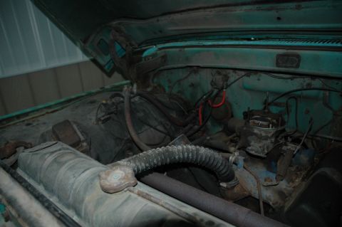 1963 Ford F-250 - The engine bay of a vintage Ford truck, likely from the early 1960s, displays its V8 engine components.