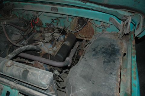 1963 Ford F-250 - Close-up view of the engine compartment of a 1963 Ford F-250, showing various mechanical parts and signs of wear.