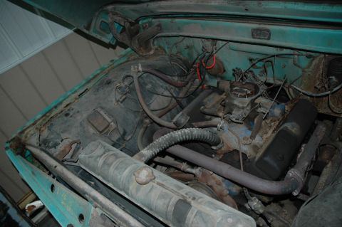 1963 Ford F-250 - The engine bay of a 1963 Ford F-250 shows its turquoise exterior paint and various engine parts.