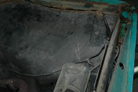 1963 Ford F-250 - The engine bay of a 1963 Ford F-250 shows signs of rust and wear, with visible wiring and components.