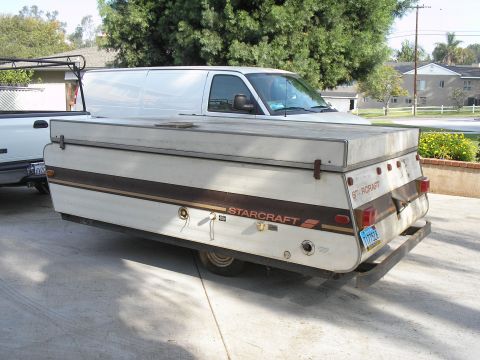 1990 Ford Bronco - A Starcraft pop-up camper is shown from the rear, parked in a driveway.