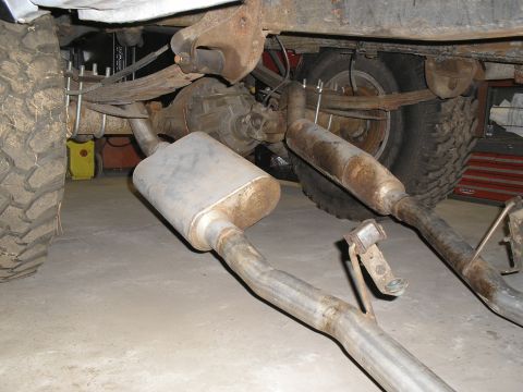 1966 Ford Bronco - Close-up view of a vehicle's rear suspension and exhaust system, showing significant rust and wear.