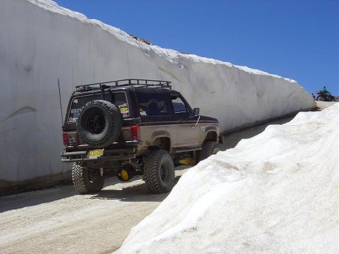 1986 Ford Bronco II - Ford Bronco II navigates a snowy mountain pass, its spare tire mounted externally.