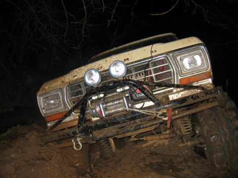 1992 Ford Mustang - This modified truck appears to be from the late 1970s, not a 1992 Ford Mustang, as it navigates a muddy obstacle.