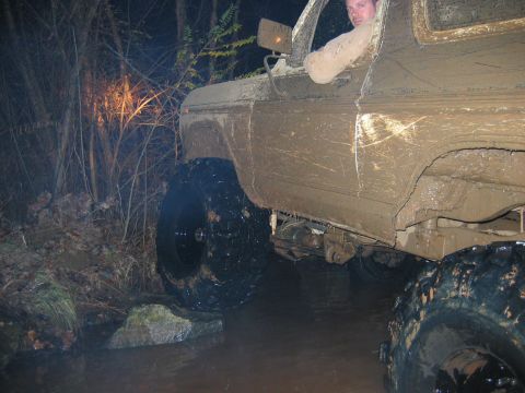 1992 Ford Mustang - A driver navigates a muddy off-road course at night, with the vehicle heavily coated in mud.