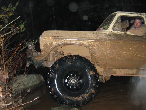 1992 Ford Mustang - This heavily mud-splattered 1979 Ford F-Series pickup truck is shown off-roading, demonstrating its capabilities.