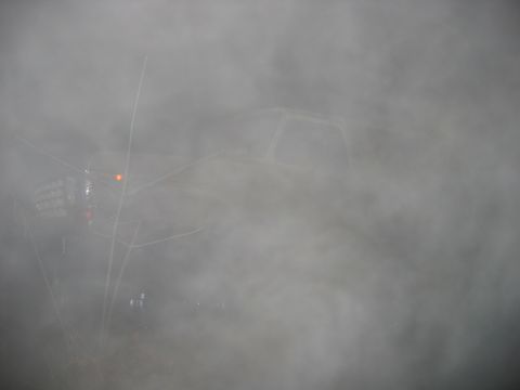 1992 Ford Mustang - A vehicle is barely visible through thick fog, obscuring details.