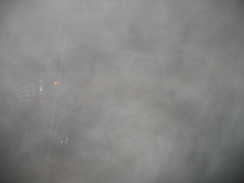 Vehicle obscured by heavy fog, only outline visible