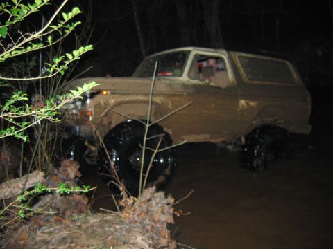 1992 Ford Mustang - A muddy 1980 Ford Bronco navigates through a dark, watery terrain.