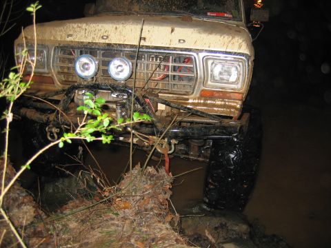 1992 Ford Mustang - This heavily modified 1979 Ford F-Series truck is shown navigating a muddy terrain, equipped with auxiliary lights and a winch for off-road…