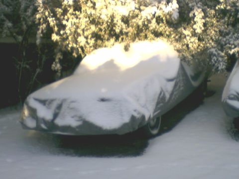 1973 Ford Ranchero - A 1973 Ford Ranchero is covered in snow, parked next to another vehicle.