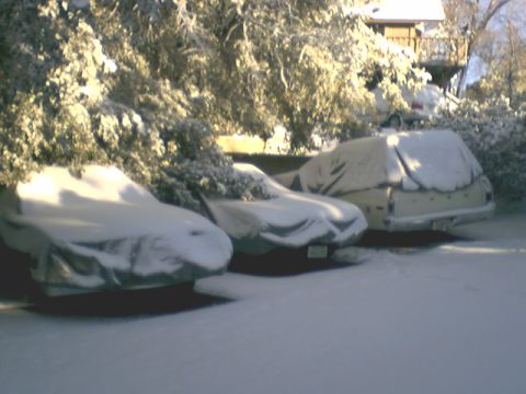 1973 Ford Ranchero - Multiple vehicles are parked outside and covered in a thick layer of snow.
