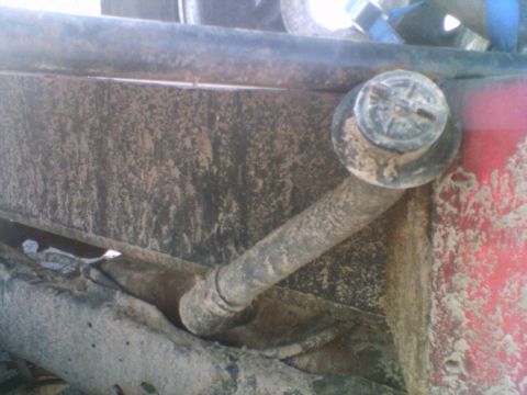 1985 Ford F-150 - Close-up view of a vehicle's fuel filler neck and cap, covered in dirt and grime.