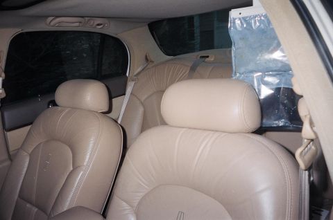 1989 Ford Bronco - Interior view of a car with tan leather seats and a plastic bag hanging from the ceiling.