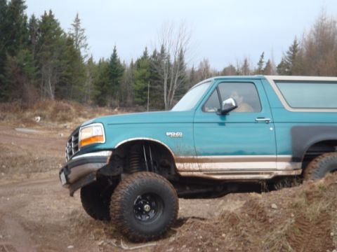 1996 Ford Bronco - 1996 Ford Bronco with lifted suspension driving off-road.