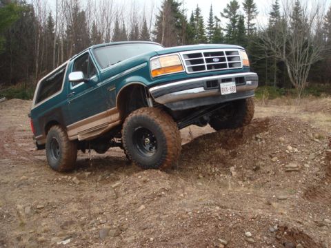 1996 Ford Bronco - This lifted 1996 Ford Bronco is shown navigating a challenging dirt terrain.