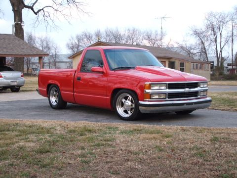 1996 Ford Probe - This red pickup truck features an aftermarket hood scoop and custom chrome wheels, giving it a distinct look.