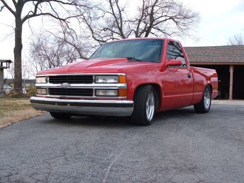 1996 Ford Probe - Red pickup truck with aftermarket hood and lowered suspension.