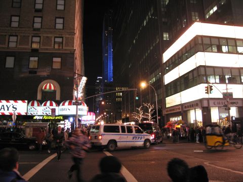 1991 Ford LTD Crown Victoria - A police van is seen on a busy street at night, illuminated by surrounding buildings and streetlights.