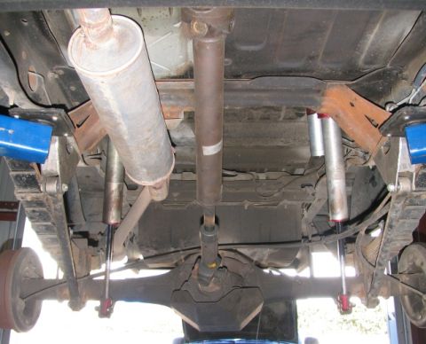 1984 Ford Bronco - Undercarriage of a vehicle, focusing on the exhaust system and suspension components.