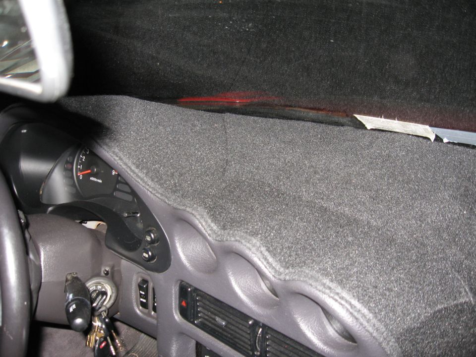 Dashboard of a 1991 Mitsubishi 3000GT with a grey carpet cover, showing the instrument cluster and steering wheel