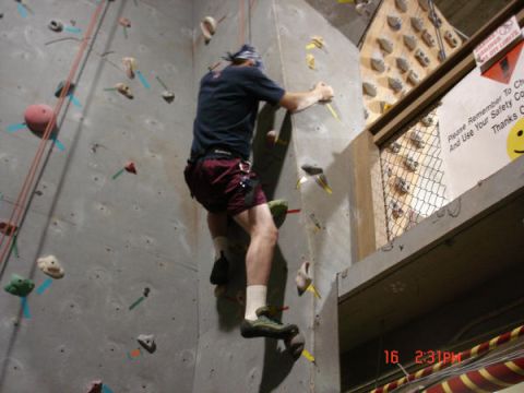 1979 Ford Bronco - A climber ascends an indoor rock wall, with safety instructions posted above.