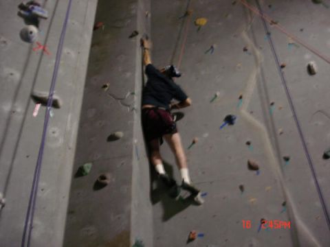 1979 Ford Bronco - A climber ascends an indoor rock wall, utilizing ropes and various colored holds for grip.