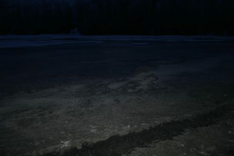 2003 Jeep TJ - Tire tracks mark a path across a dark, frozen landscape under a night sky.